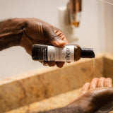 man pouring zenore beard wash into hand
