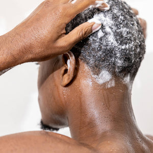 man washing hair with zenore shampoo in shower